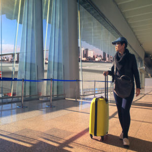 traveling woman and luggage walking in airport terminal and air