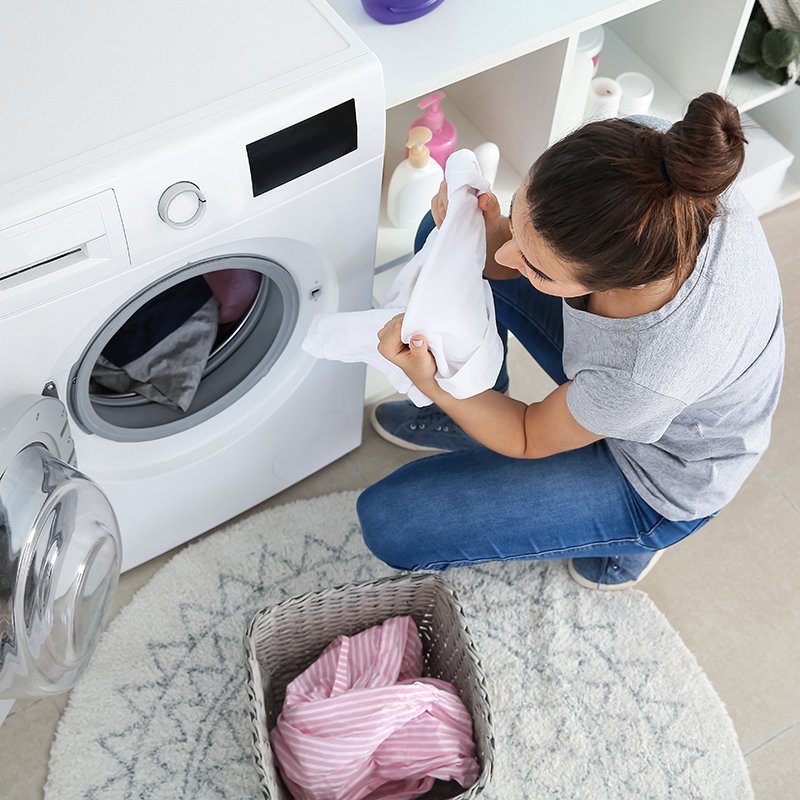 beautiful young woman doing laundry at home